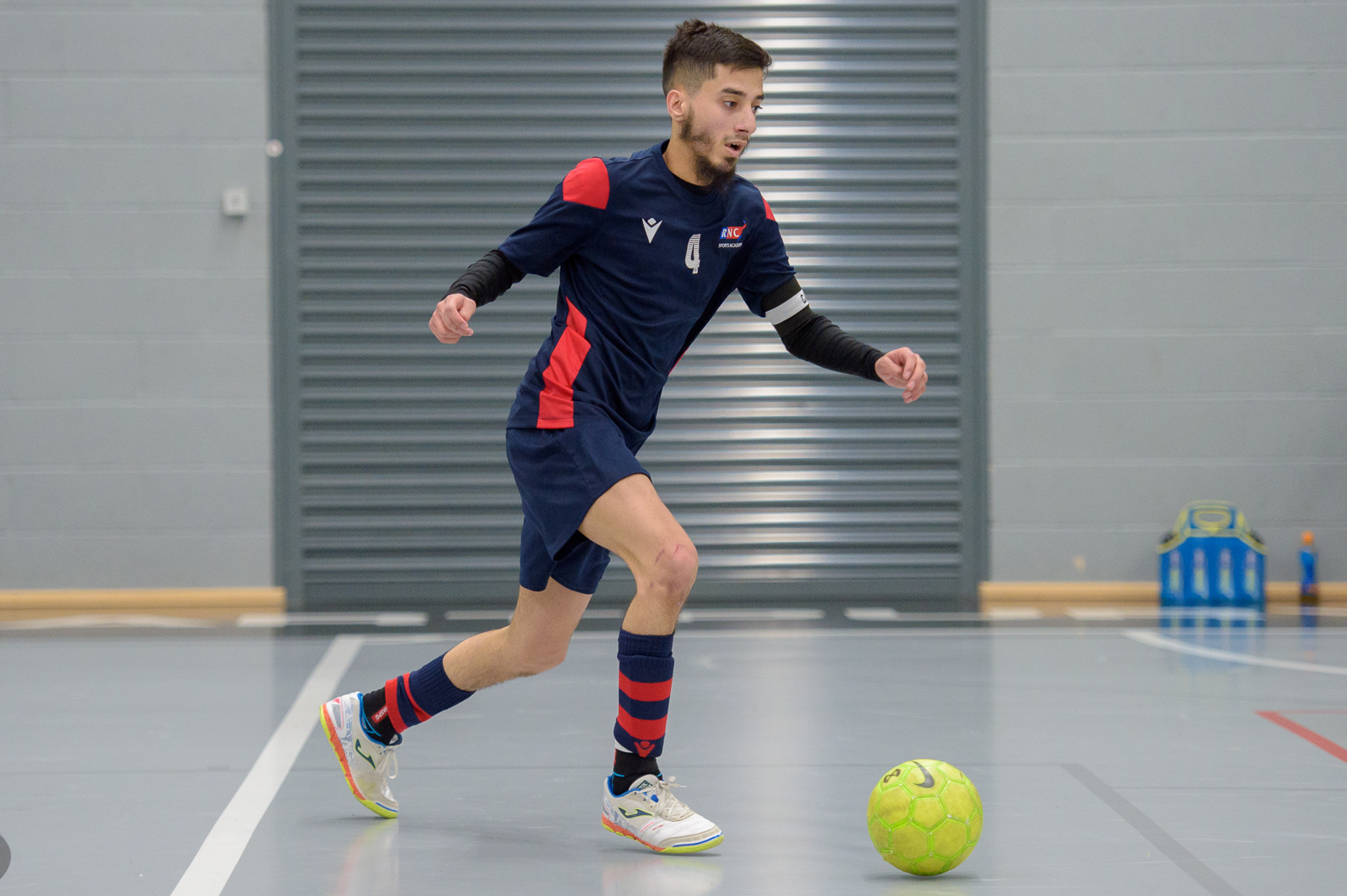 a player dribbling with the ball during a partially sighted futsal match