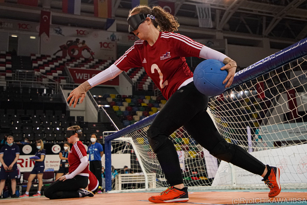 A goalball player on the court just about to release the ball from a standing position