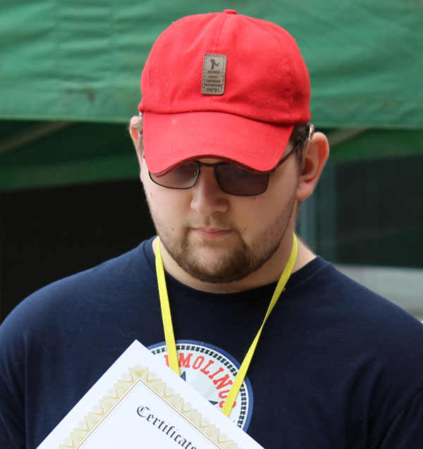 A headshot of Eddie wearing a red baseball cap
