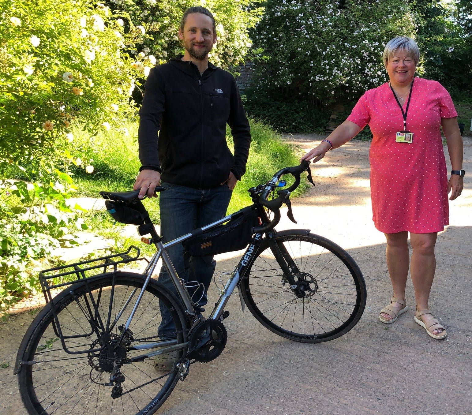 Andrew stands by his bike with Melanie to his left