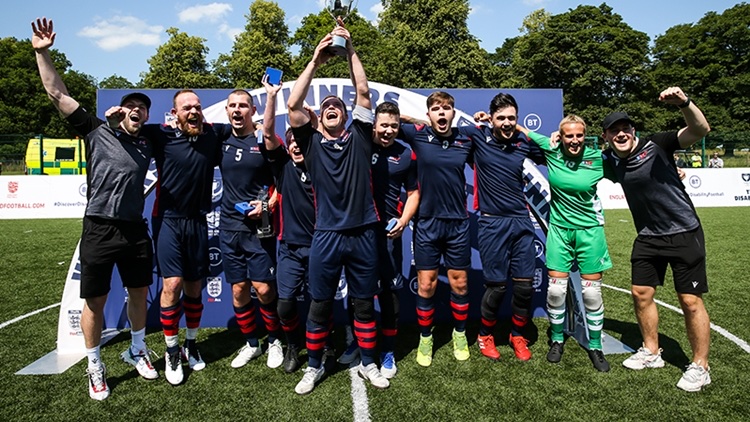 The whole squad celebrate lifting the trophy in front of the winners arch