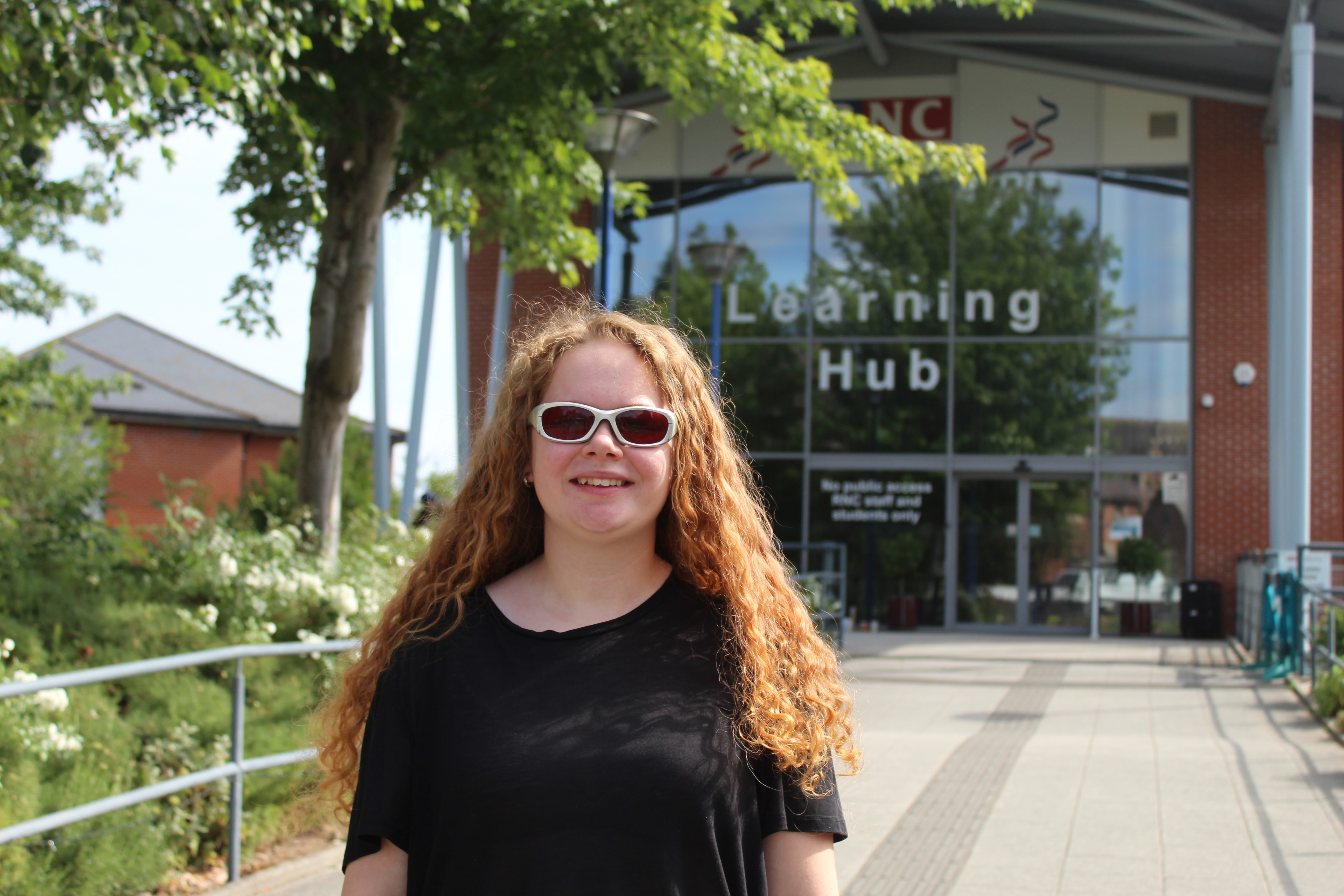 Amelie standing in front of the College's Learning Hub entrance