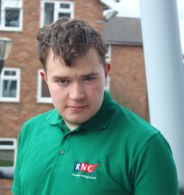 a portrait of Fionn wearing his green student ambassador shirt