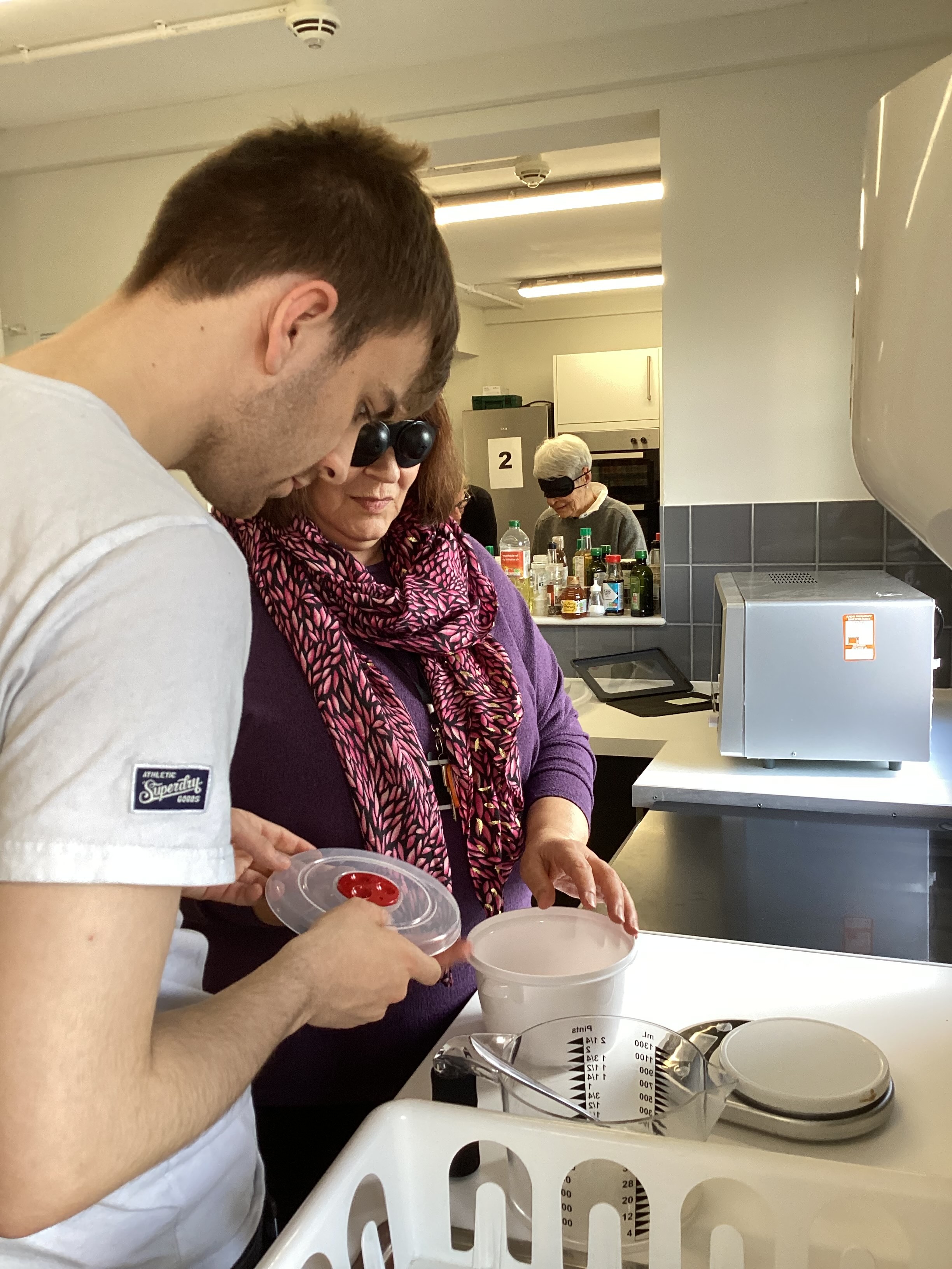 Sam assists one of the governors with the cooking task in the ILS kitchen