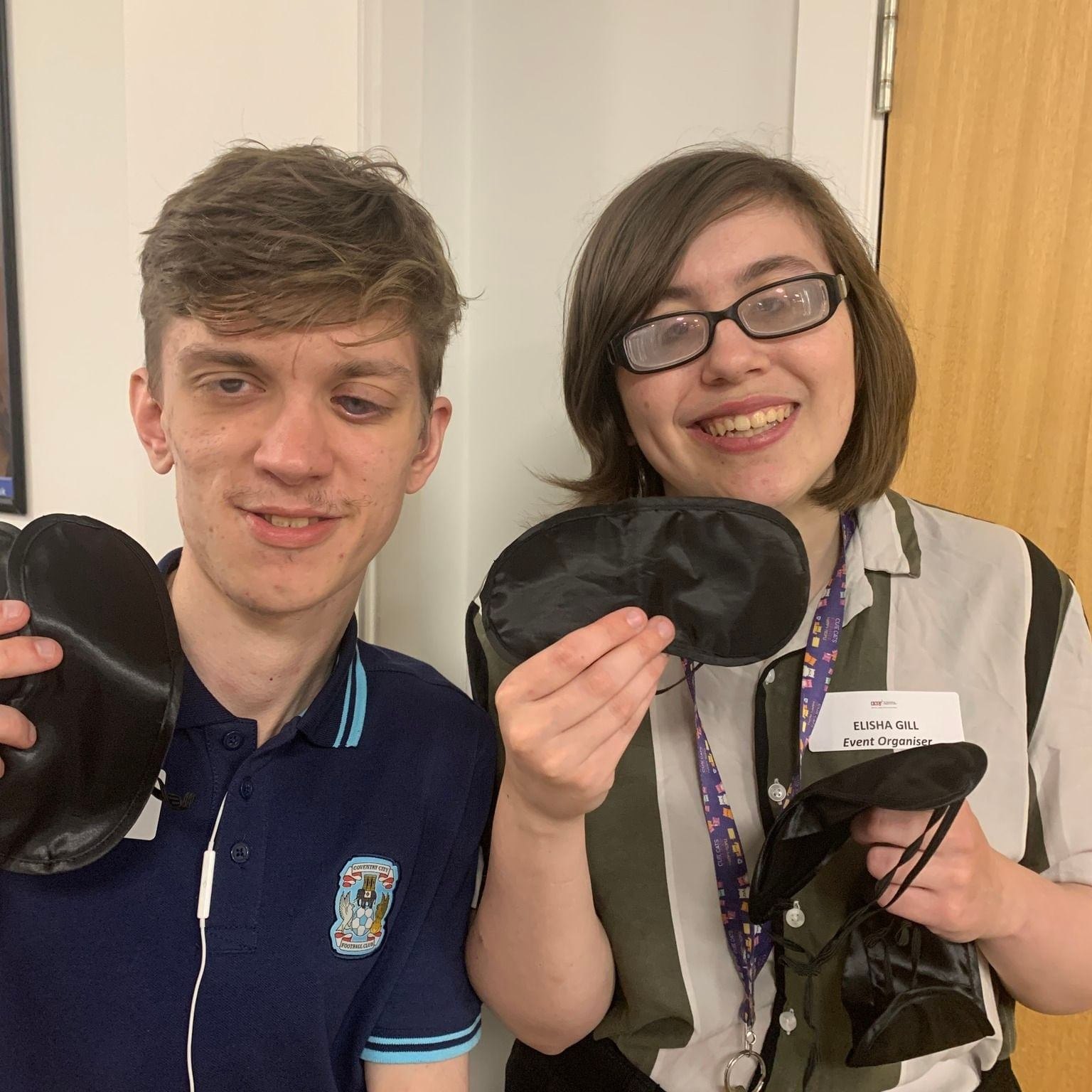 two students holding blindfolds ready to hand to their guests