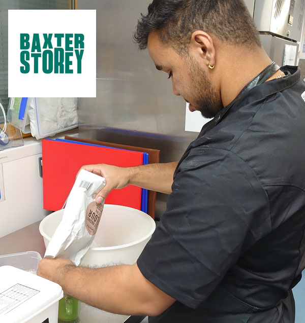 Kai pouring flour into a green cup to measure it out