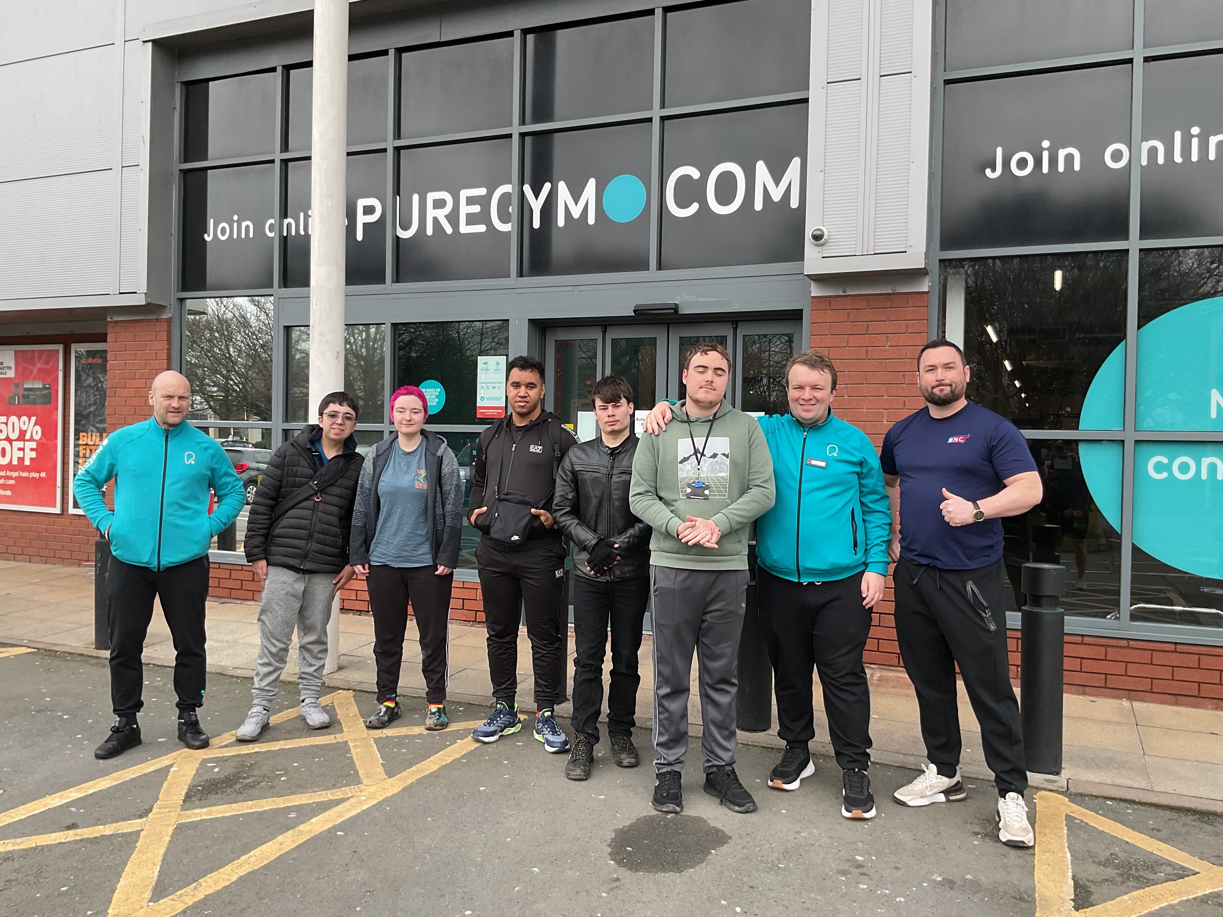 Pure Gym staff and RNC staff and students stand outside the entrance to Pure Gym
