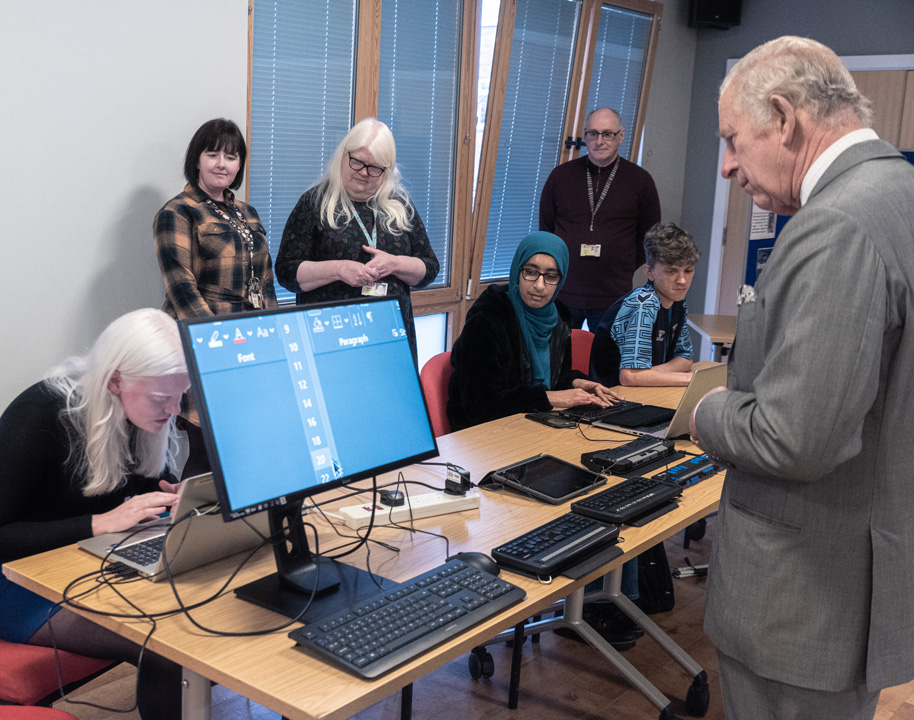 A student demonstrating ZoomText as the King watches on