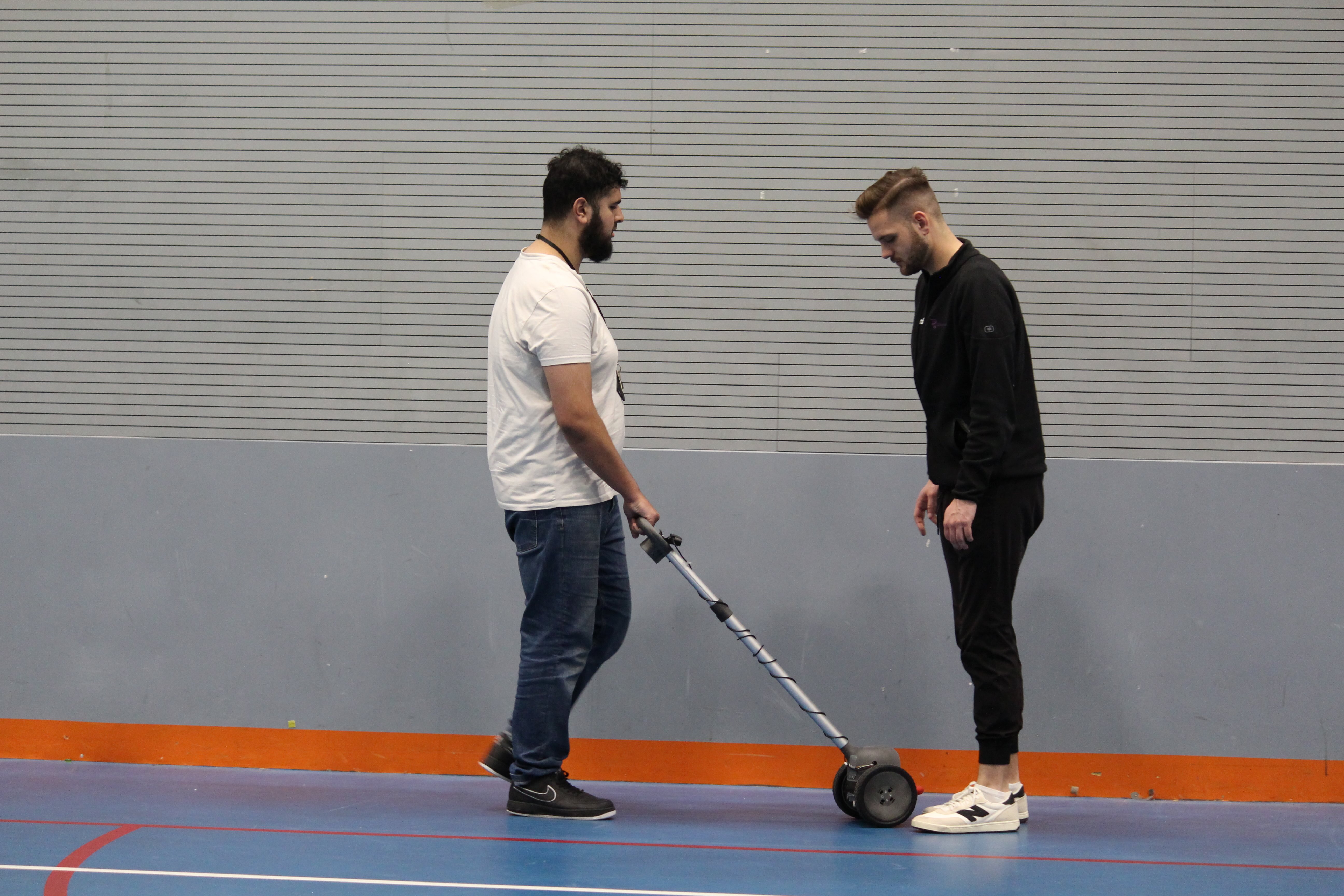 a student using the Glide, a man stands in its path to demonstrate its quick reaction